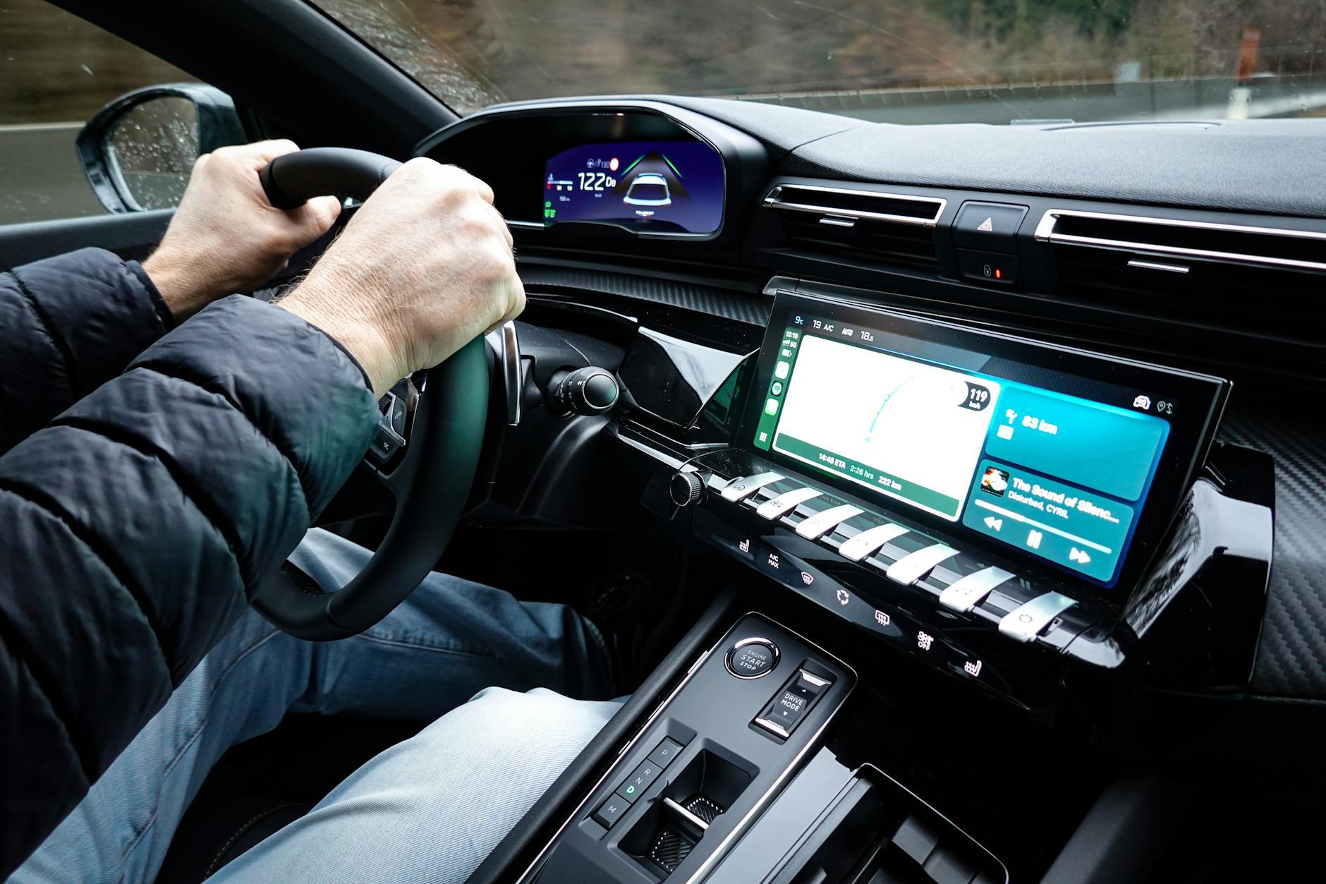 Wnętrze hybrydowej Toyoty z kierowcą trzymającym dłonie na kierownicy