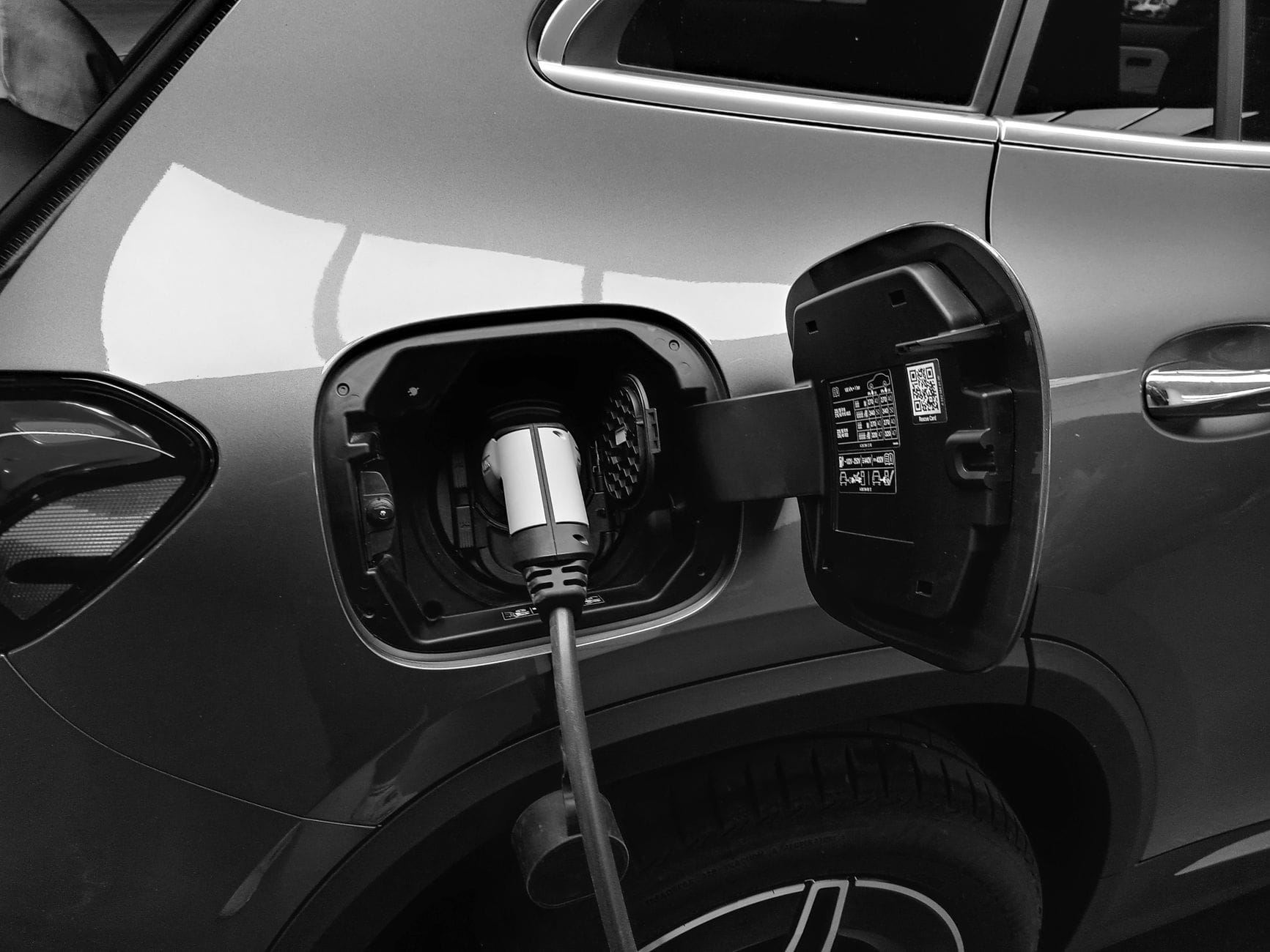 Zbliżenie na ładowanie elektrycznego SUV‑a przy stacji