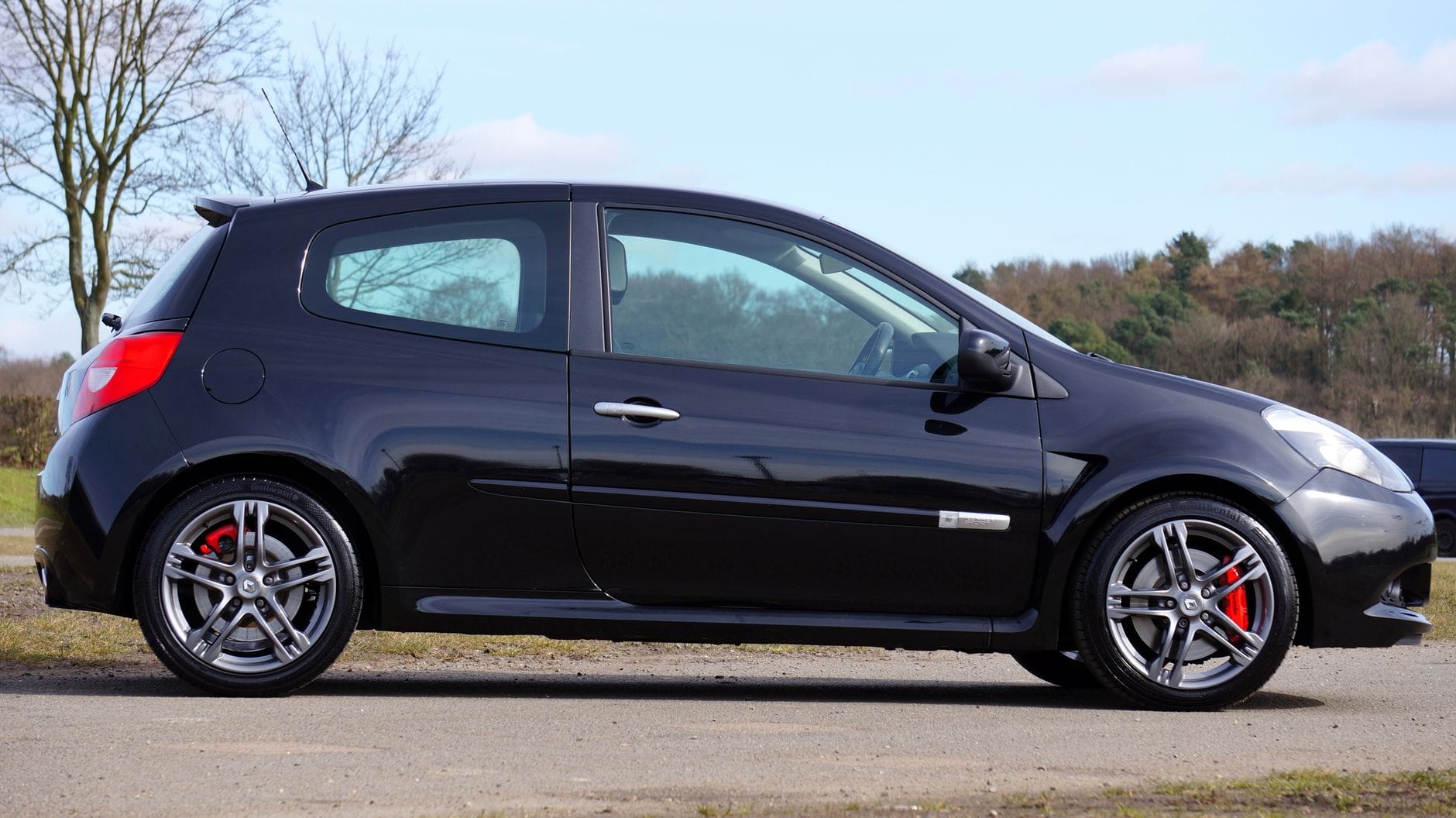 Czarne Renault Clio RS zaparkowane wśród drzew w naturalnym otoczeniu